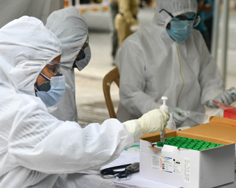New Delhi: Health workers wearing Personal Protective Equipment (PPE) suits collect swab samples from people at a COVID-19 testing center in New Delhi during the extended nationwide lockdown imposed to mitigate the spread of coronavirus; on Apr 23, 2