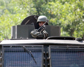 Kupwara: A security personnel takes position atop a military vehicle during search operations after an army commando was killed and another injured in a gunfight between hiding militants and security forces in a forested area of Jammu and Kashmir
