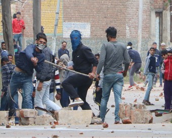 Srinagar: Protesters pelt stones on security personnel during the ongoing municipal polls in Soura area of Srinagar on Oct 16, 2018.