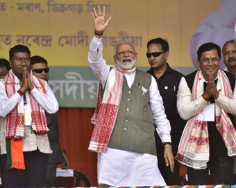 Moran: Prime Minister and BJP leader Narendra Modi accompanied by Assam Chief Minister and party leader Sarbananda Sonowal, waves at supporters during a public meeting at Moran in Assam