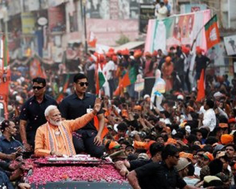 Varanasi: Prime Minister Narendra Modi waves at his supporters during a roadshow ahead of the 2019 Lok Sabha elections, in Varanasi on April 25, 2019. (Photo: IANS)
