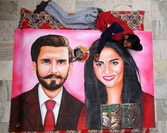 Amritsar: A fan gives finishing touches to the portrait of actors Ranveer Singh and Deepika Padukone, who will tie the knot in a ceremony which will take place over two days on November 14-15 in Italy