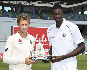 Joe Root and Jason Holder holding the #RaiseTheBat series trophy