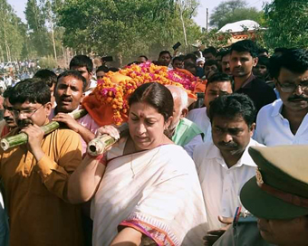 Uttar Pradesh : BJP MP from Amethi constituency Smriti Irani lends a shoulder to mortal remains of BJP worker Surendra Singh who was shot dead in Amethi on Sunday. (ANI Photo)