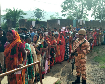 Sahibganj: A soldier stands guard as people wait in queue to cast votes during the seventh and the last phase of 2019 Lok Sabha Elections at a polling booth in Sahibganj, Jharkhand, on May 19, 2019. (Photo: IANS/ITBP)
