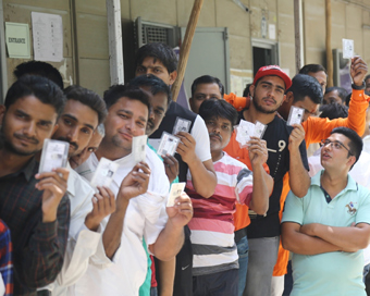 New Delhi: People show their voter identity card at a polling booth during the sixth phase of 2019 Lok Sabha elections, in New Delhi on May 12, 2019. (Photo: IANS)